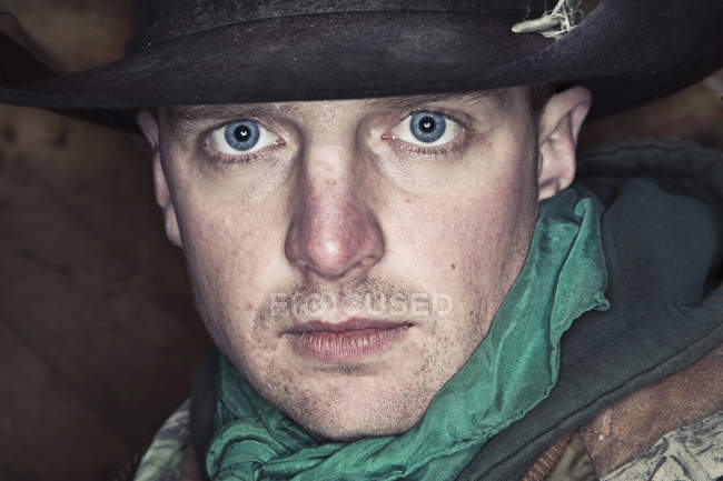 Retrato de hombre con ojos azules brillantes en sombrero mirando en cámara . - foto de stock