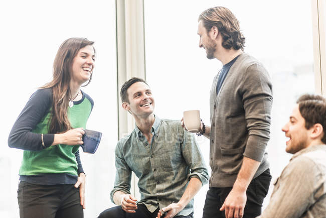 Colleagues laughing together on coffee break. — Stock Photo