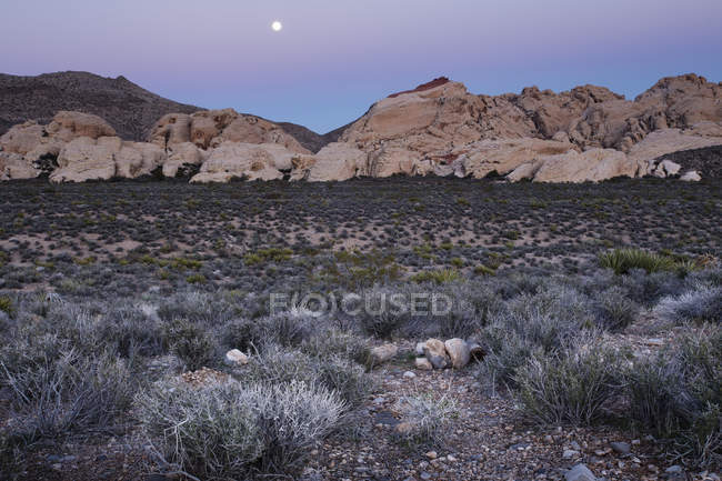 Mond steigt über Berge in roter Felsschlucht in Nevada. — Stockfoto