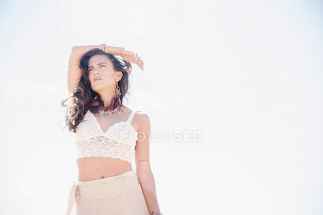 Young woman with long brown hair in lace top and skirt. — Stock Photo