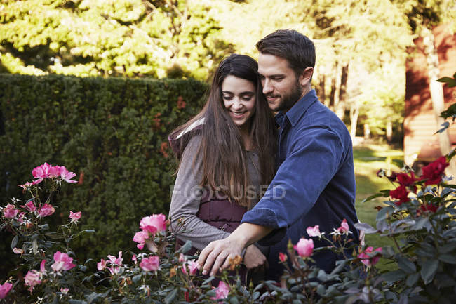 Jeune homme et femme regardant les plantes exposées au centre de jardin . — Photo de stock