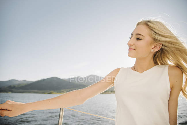 Блондинка дівчина-підліток розслабляється на вітрильному човні . — стокове фото