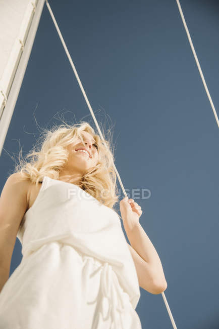 Loira adolescente sob vela no barco, visão de baixo ângulo . — Fotografia de Stock