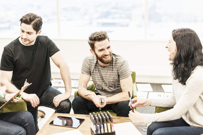 Colleagues at planning meeting holding colored pens. — Stock Photo