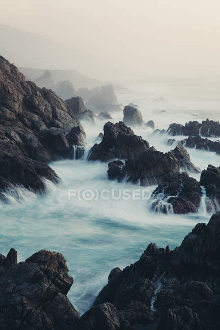 Olas estrellándose contra la costa rocosa en la costa del Océano Pacífico . - foto de stock