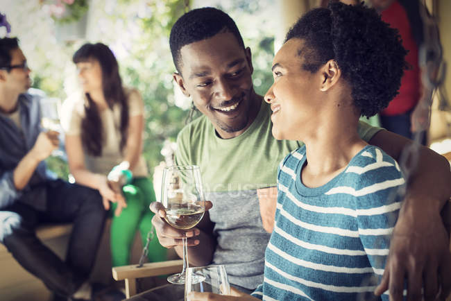 Coppia che beve da bicchieri di vino con gruppo di amici alla festa di casa . — Foto stock
