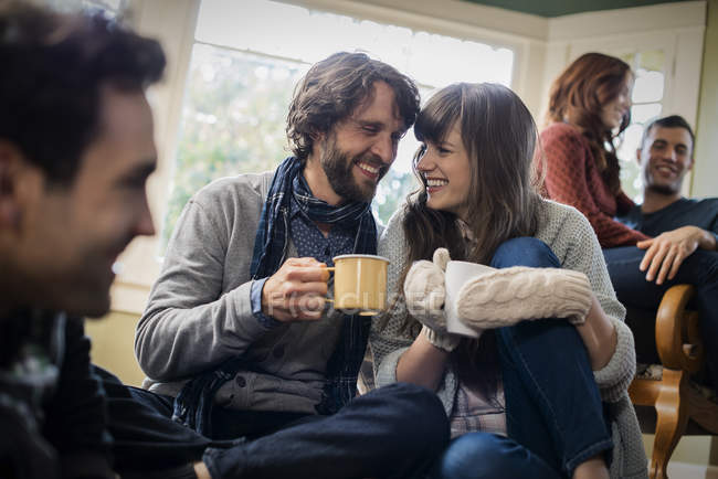 Group of men and women warming up with hot drinks. — Stock Photo