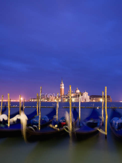 Гондоли човни пришвартовані на узбережжі з видом на острів і церкву Сан-Джорджо-Маджоре у сутінках, Венеція, Італія. — стокове фото