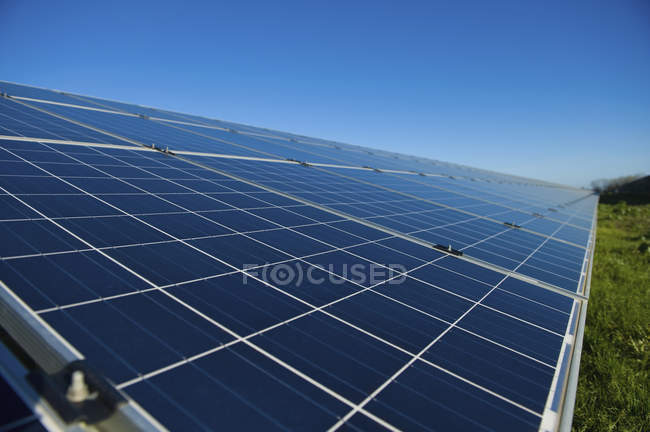Nahaufnahme einer Reihe von Sonnenkollektoren im offenen Feld eines Solarparks. — Stockfoto
