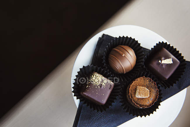 Surtido de dulces de chocolate hechos a mano en el plato . - foto de stock