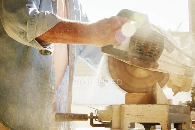 Cropped view of senior man using circular saw. — Stock Photo