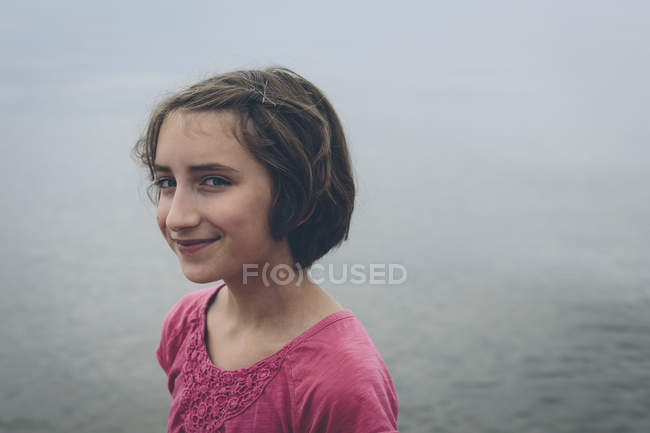 Portrait de préadolescente souriante devant l'eau du lac . — Photo de stock