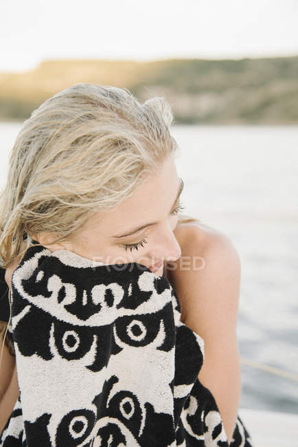 Mujer rubia secando el cabello mojado con toalla en el lago . - foto de stock