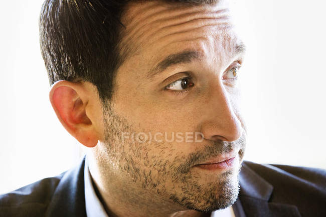 Portrait of businessman with brown hair and stubble in suit. — Stock Photo