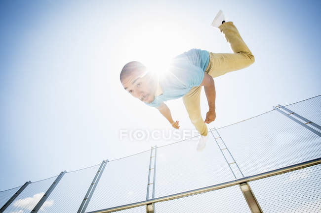 Молодий чоловік сальто на міському мосту, низький кут зору . — стокове фото