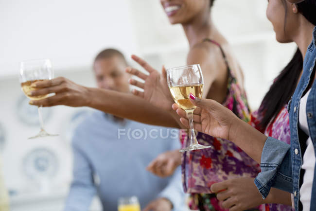Vista cortada de pessoas segurando copos de vinho em cima da mesa buffet . — Fotografia de Stock