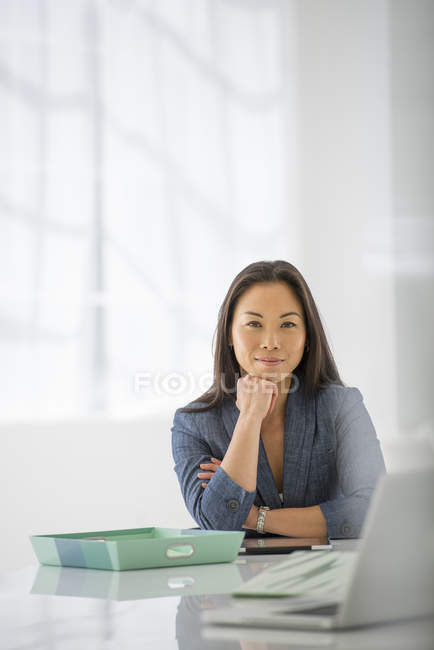 Жінка з руки на Хін розслабляючий в офісному столі з ноутбук і зелений папки. — стокове фото