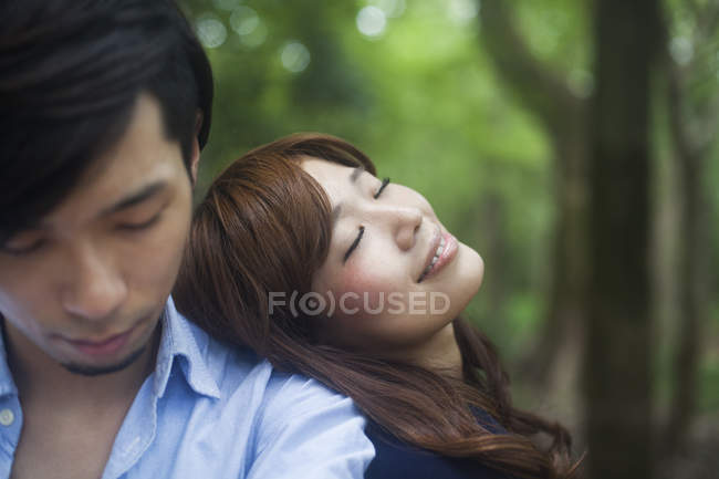 Young woman leaning on boyfriend shoulder in park. — Stock Photo