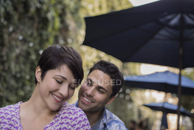 Man and woman sitting at city cafe and smiling. — Stock Photo