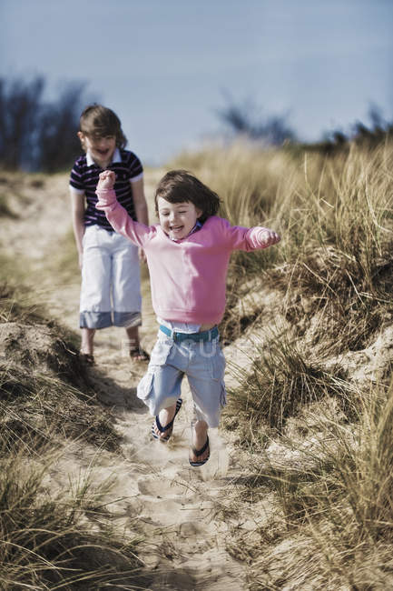 Due bambini in età elementare che giocano nelle dune di sabbia . — Foto stock