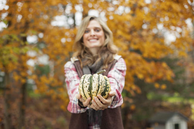 Жінка тримає великі смугасті кабачки овочеві . — стокове фото
