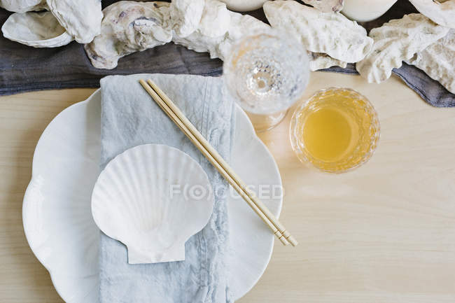 Place setting at table with drinking glasses and wooden chopsticks. — Stock Photo