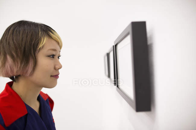 Nahaufnahme einer jungen Frau beim Betrachten von Kunstwerken im Atelier. — Stockfoto