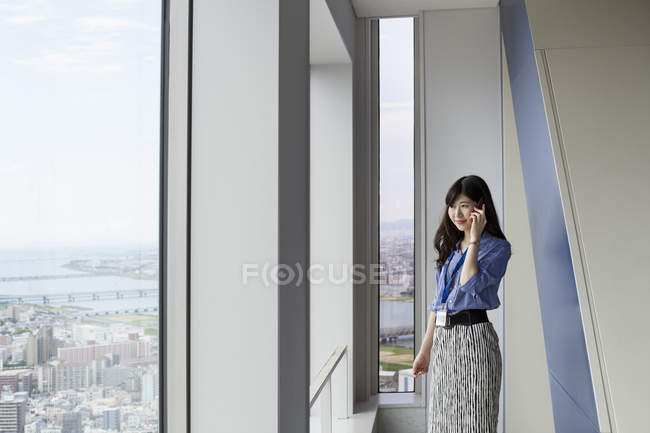 Empresária japonesa falando por telefone no prédio de escritórios . — Fotografia de Stock