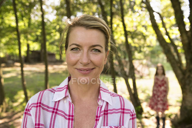 Mother and daughter in shade of trees in summer. — Stock Photo