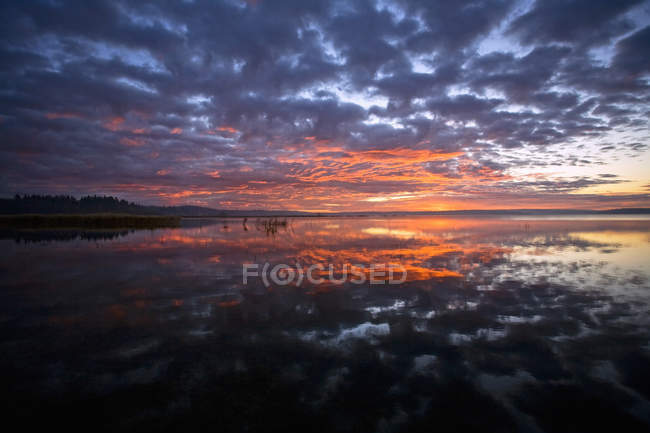 Céu do pôr do sol refletindo na superfície do lago no Canadá — Fotografia de Stock
