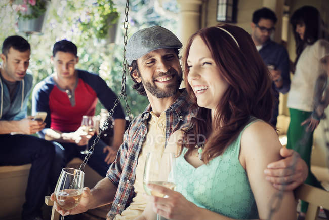 Man and woman drinking win with fiends at house party. — Stock Photo