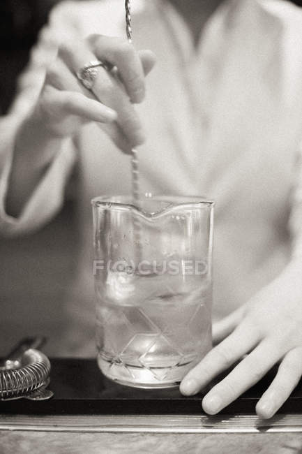 Primo piano di mixologist mano cocktail miscelazione in vetro di rocce . — Foto stock