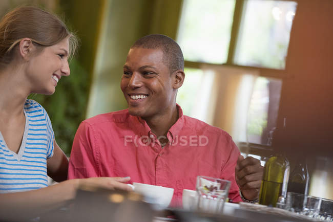Hombre y mujer sentados juntos y sonriendo en la cafetería . - foto de stock