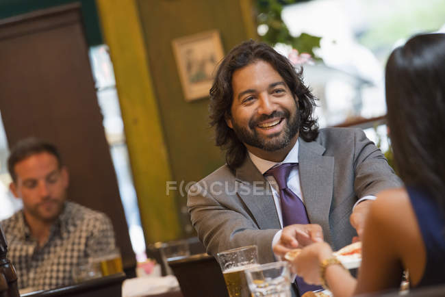 Paar lächelnd und Händchenhaltend am Tisch im Pub-Inneren. — Stockfoto