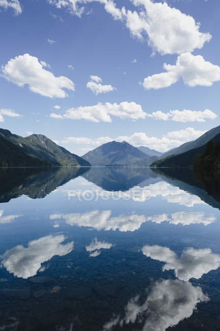 Mirror reflection of sky and clouds in water of Lake Crescent, Washington, USA. — Stock Photo