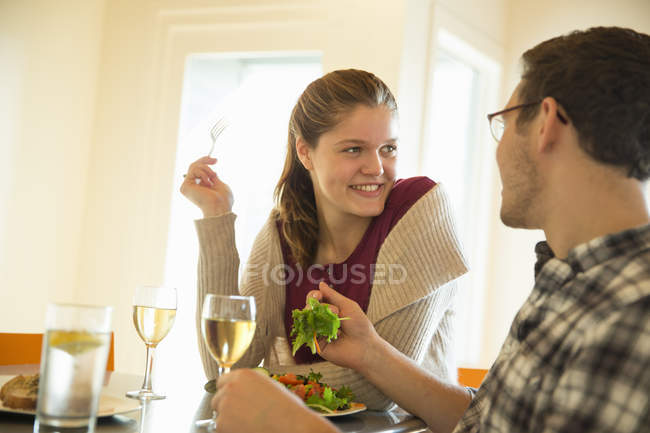 Jeune homme et femme mangeant et buvant du vin au café . — Photo de stock