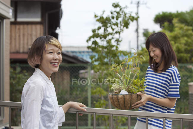 Due donne giapponesi in piedi in giardino con piante in vaso . — Foto stock