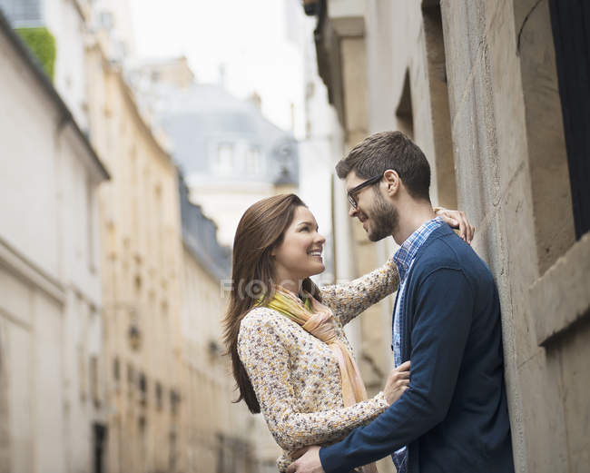 Mittleres erwachsenes Paar, das in einer engen Straße in der Stadt steht und einander ansieht. — Stockfoto