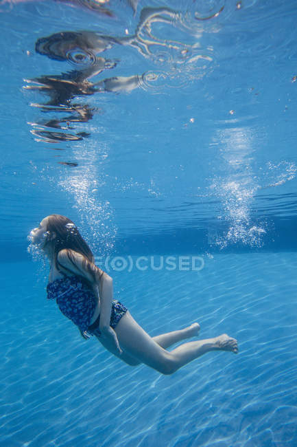 Попередньо підлітків дівчина з Фаннінг довге волосся підводного плавання в басейні. — стокове фото