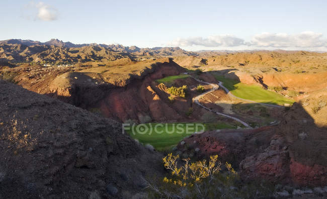 Elevated view over mountains and desert landscape with golf course in valley in Arizona. — Stock Photo