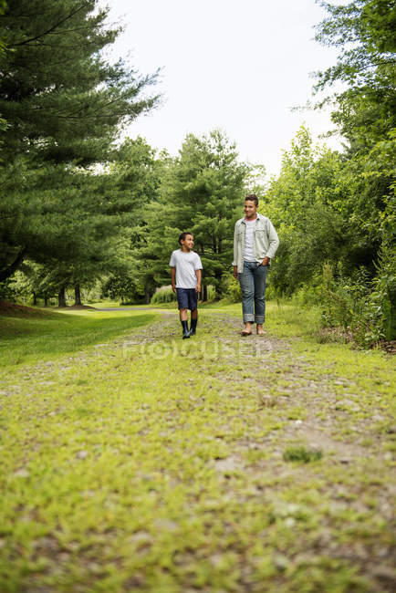 Two brothers walking on country path in woodland, front view. — Stock Photo