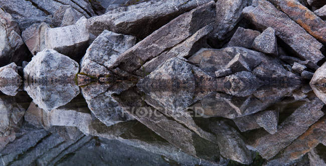 Скалистые скалы, отражающиеся в спокойной воде озера Подкова, Национальный парк Джаспер, Альберта, Канада . — стоковое фото