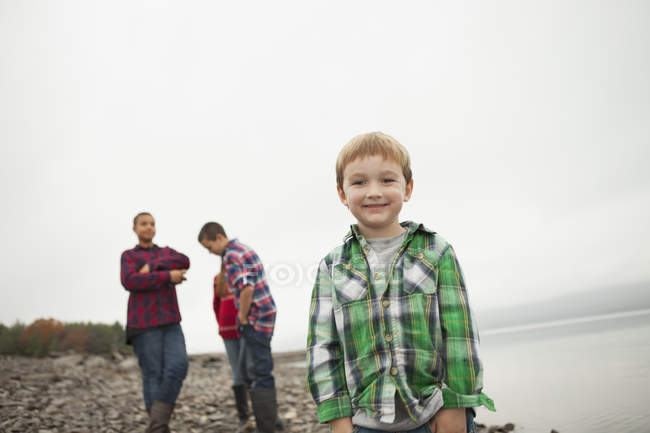 Teenager und Junge im Grundschulalter stehen am Ufer. — Stockfoto