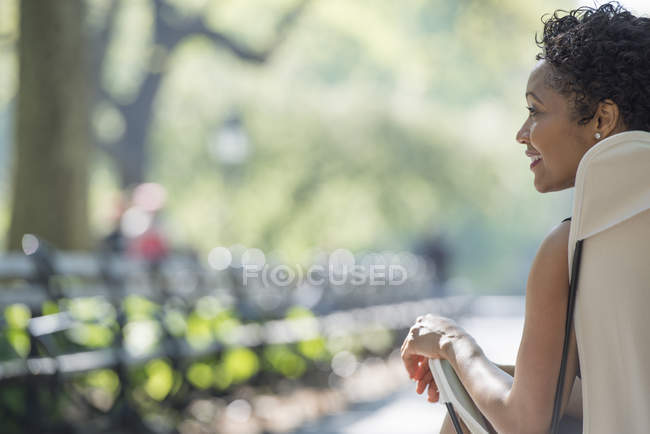 Woman sitting in camping chair in city park. — Stock Photo