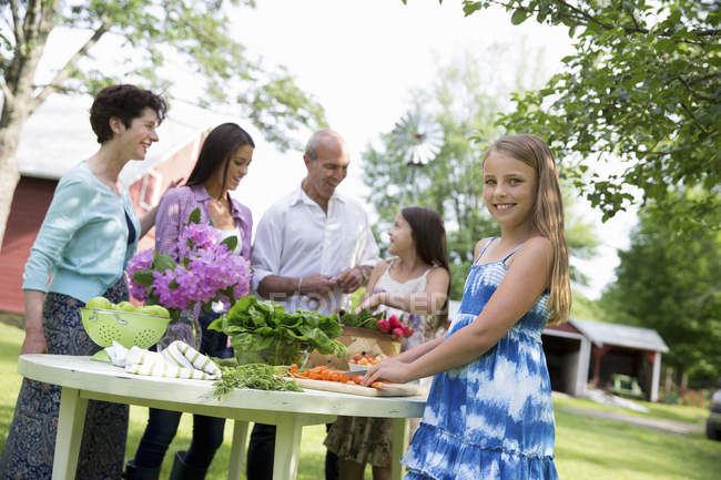 Familie trifft sich am Tisch und bereitet frisches Gemüse und Obst zu. — Stockfoto