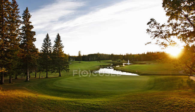 Green golf course fairway with water hazard in Canada. — Stock Photo