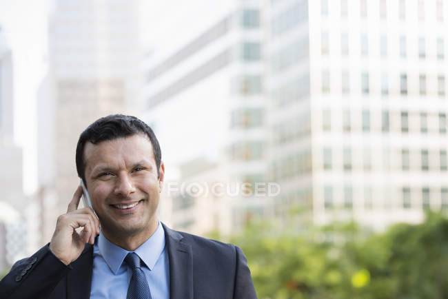 Front view of businessman talking on phone on urban street. — Stock Photo