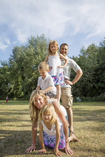 Família com três filhos posando enquanto brincava no parque . — Fotografia de Stock