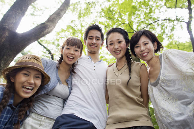 Tiefansicht japanischer Freunde, die im Wald posieren und sich umarmen. — Stockfoto