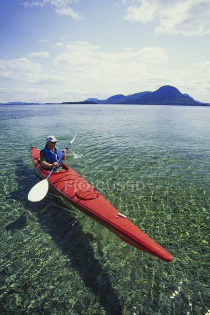 Man in sea kayak on calm water off shore of Ketchikan, Alaska, EUA . — Fotografia de Stock